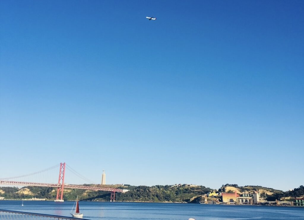 View of the Tagus River and 25 de Abril Bridge in Lisbon under a clear blue sky during the best first date