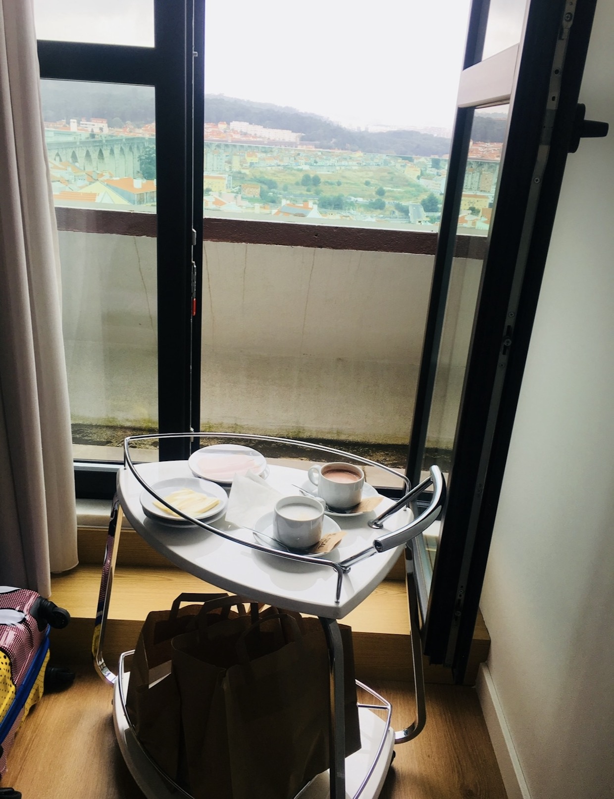 Morning coffee and breakfast by an open window with a Lisbon view
