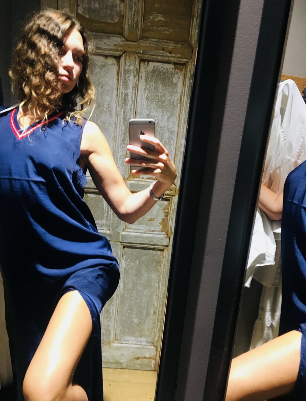 Trying on a blue dress in a fitting room before a solo date in Lisbon